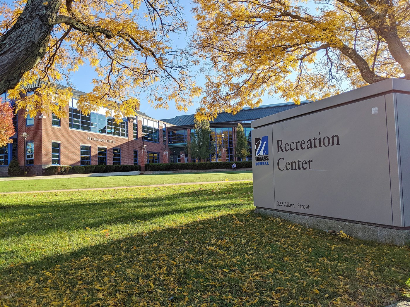 Exterior of Campus Recreation Center in fall with sign in foreground.